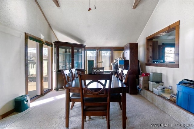 carpeted dining space featuring a wealth of natural light, lofted ceiling with beams, and a textured ceiling