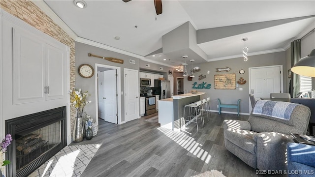 living room featuring vaulted ceiling, dark wood-type flooring, crown molding, and ceiling fan