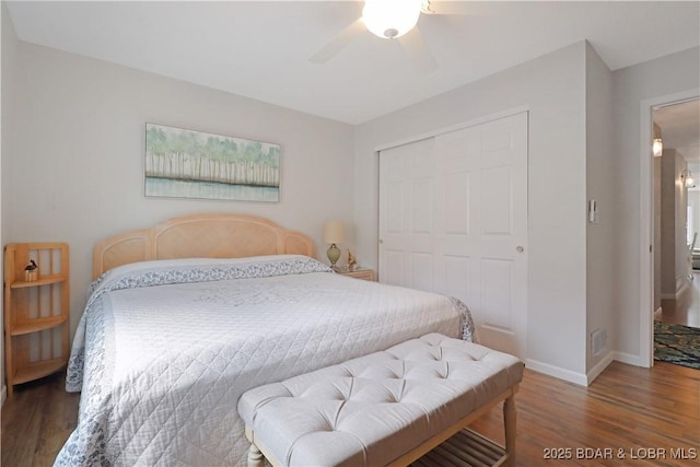 bedroom featuring dark hardwood / wood-style flooring, ceiling fan, and a closet