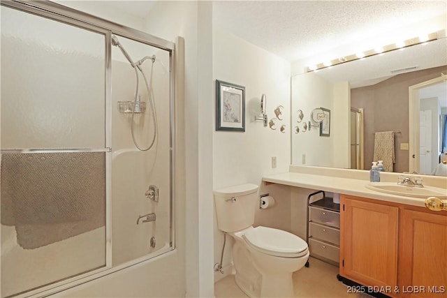 full bathroom featuring enclosed tub / shower combo, vanity, a textured ceiling, and toilet