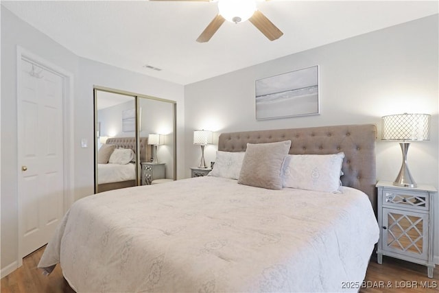 bedroom featuring dark wood-type flooring, ceiling fan, and a closet