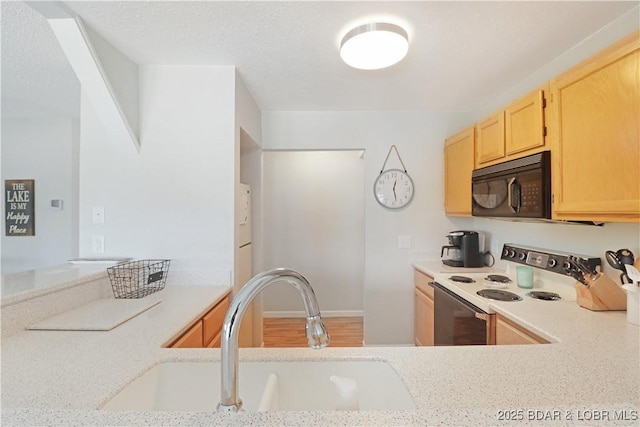 kitchen featuring light brown cabinetry, sink, light stone counters, and white range with electric stovetop