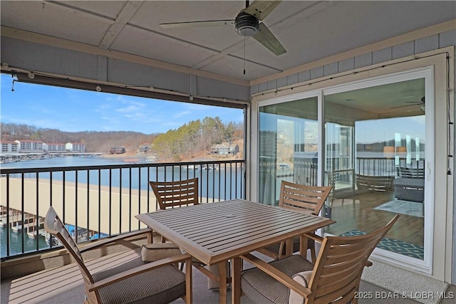 balcony featuring a water view and ceiling fan