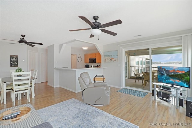 living room featuring light hardwood / wood-style flooring and ceiling fan