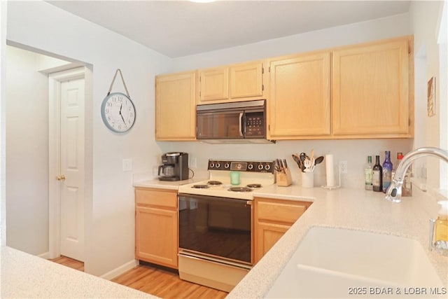 kitchen with sink, white electric range, light hardwood / wood-style flooring, and light brown cabinets