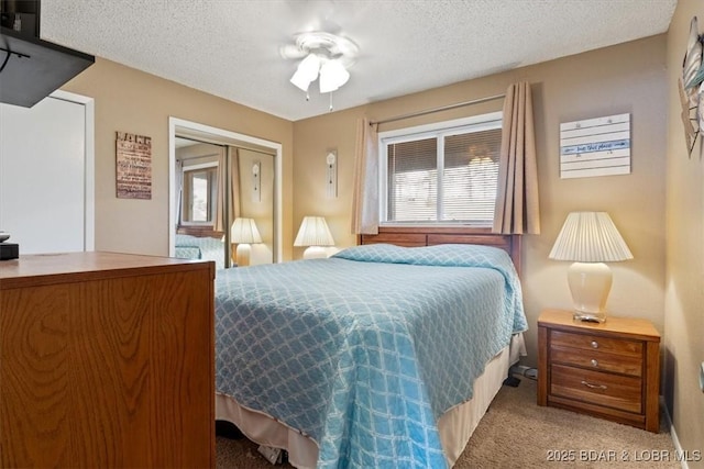 carpeted bedroom featuring a textured ceiling, a closet, and ceiling fan