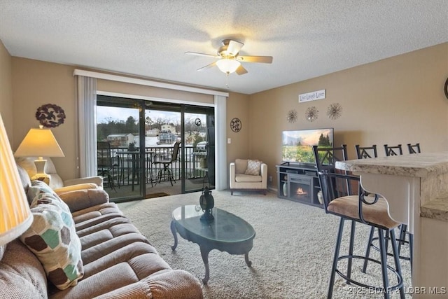 living room with ceiling fan, a textured ceiling, and carpet flooring