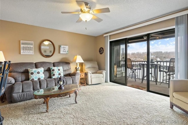 living room featuring ceiling fan and a textured ceiling