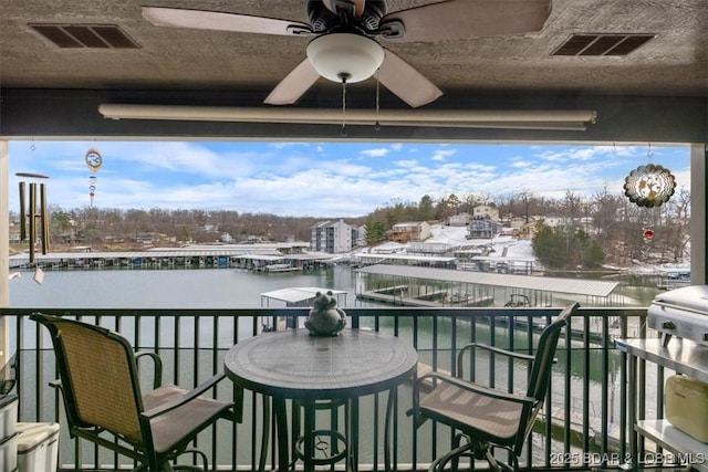 balcony featuring ceiling fan and a water view