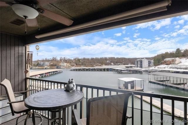 balcony featuring a water view and ceiling fan