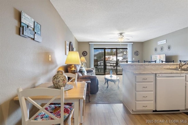 kitchen featuring white cabinetry, ceiling fan, white dishwasher, a textured ceiling, and light wood-type flooring