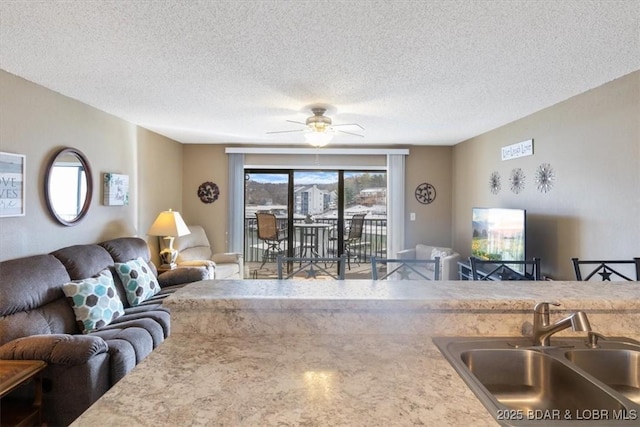 interior space with ceiling fan, sink, and a textured ceiling