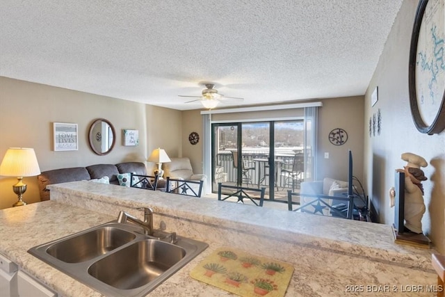 kitchen featuring ceiling fan, sink, and a textured ceiling