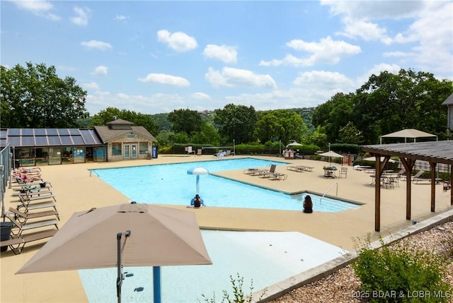 view of swimming pool featuring an outdoor structure, a pergola, and a patio area