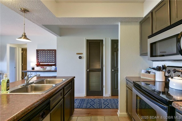 kitchen with stainless steel appliances, decorative light fixtures, sink, and light tile patterned floors