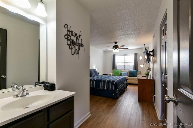 bedroom featuring wood-type flooring, sink, and a textured ceiling