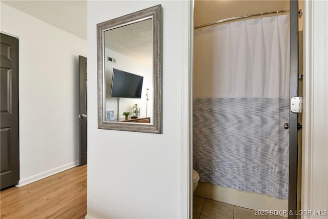 bathroom with hardwood / wood-style floors and toilet