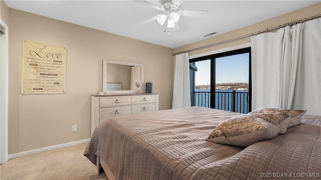 carpeted bedroom with access to outside, ceiling fan, and a water view