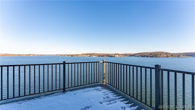 dock area with a water view and a balcony