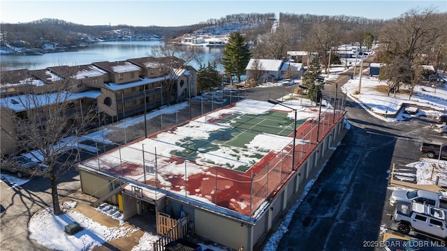 snowy aerial view featuring a water view