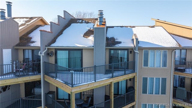 view of snow covered back of property