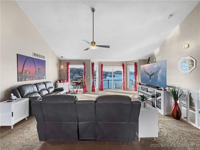 carpeted living room with ceiling fan and high vaulted ceiling