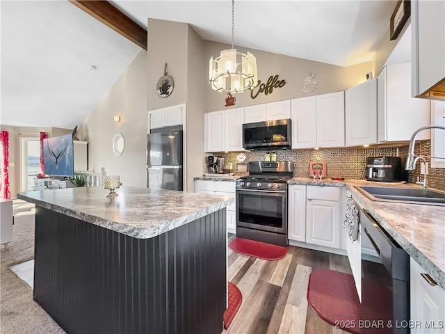 kitchen with white cabinetry, sink, backsplash, stainless steel appliances, and beam ceiling