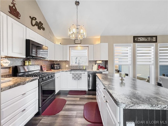 kitchen with a kitchen island, sink, white cabinets, backsplash, and stainless steel appliances