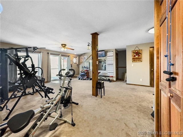 workout room with ceiling fan and light carpet