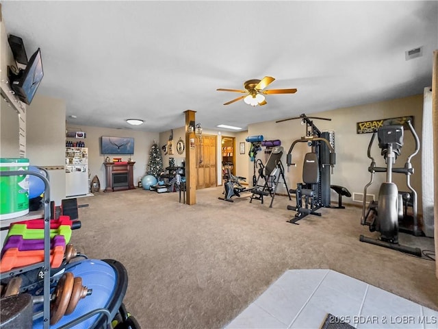 exercise room with carpet floors and ceiling fan