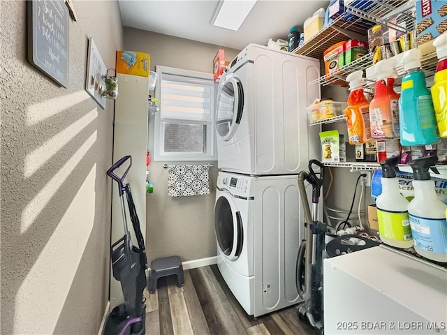 clothes washing area featuring dark hardwood / wood-style flooring and stacked washer and clothes dryer