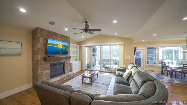 living room featuring a fireplace, vaulted ceiling, hardwood / wood-style floors, and a healthy amount of sunlight