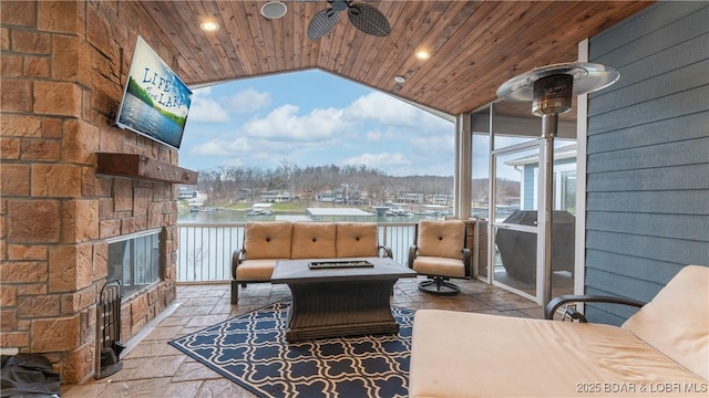 view of patio featuring grilling area, ceiling fan, and an outdoor living space with a fire pit