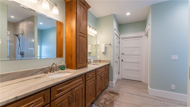 bathroom featuring vanity, a shower, and wood-type flooring