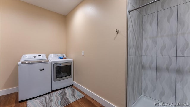 washroom with hardwood / wood-style flooring and washing machine and clothes dryer