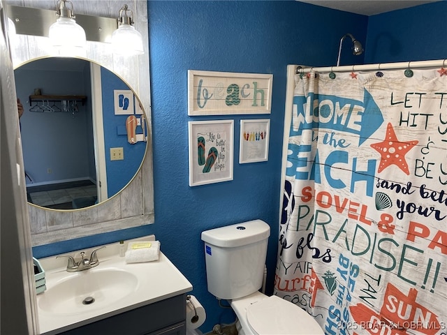 bathroom featuring vanity, curtained shower, and toilet