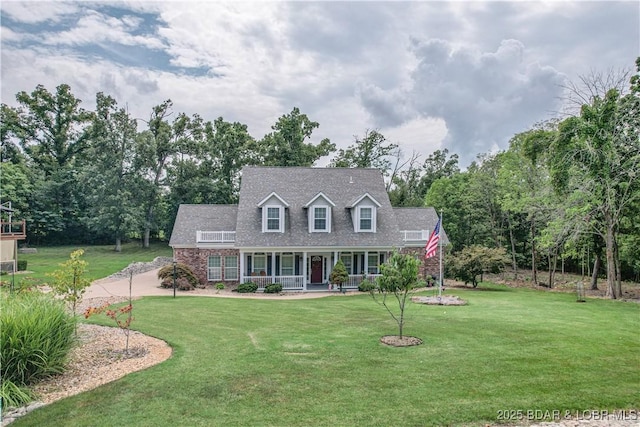 cape cod house with covered porch and a front lawn