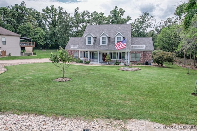 cape cod house featuring a front yard and covered porch