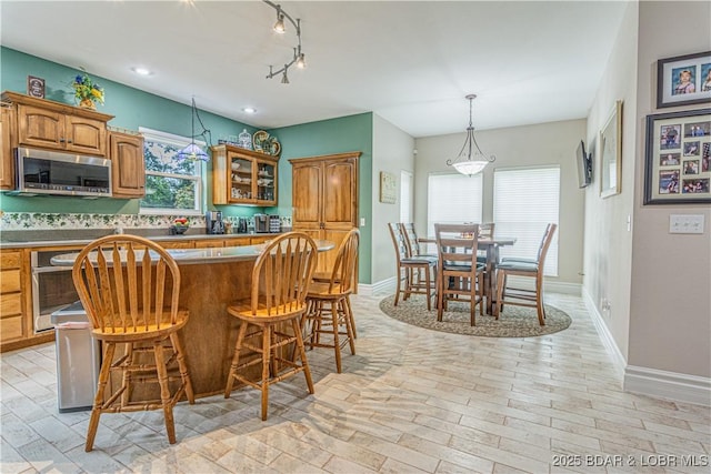 kitchen with rail lighting, pendant lighting, and a breakfast bar area