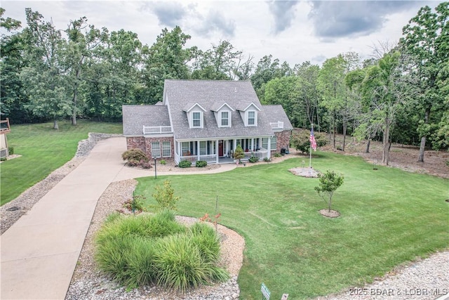 cape cod-style house with a front lawn and covered porch