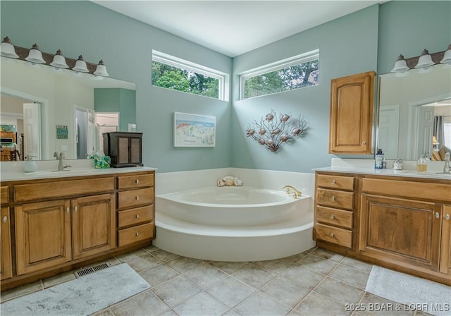 bathroom featuring vanity, a bath, and tile patterned flooring