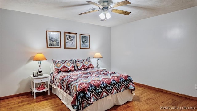 bedroom featuring wood finished floors, baseboards, and ceiling fan