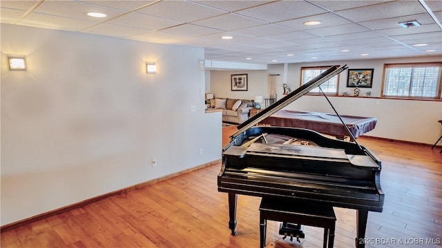 misc room with a paneled ceiling and light hardwood / wood-style floors