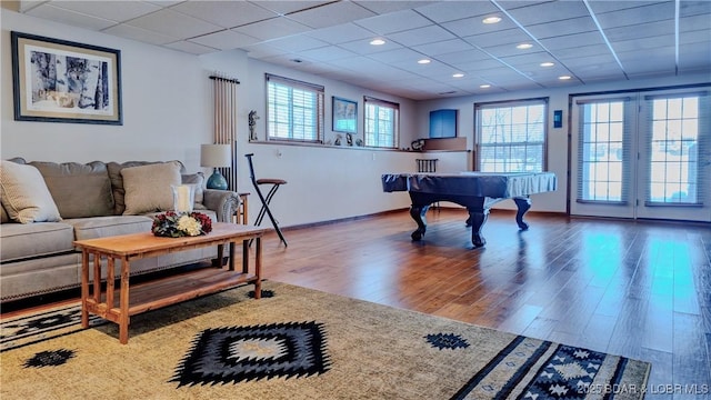 recreation room with recessed lighting, baseboards, a paneled ceiling, and wood finished floors