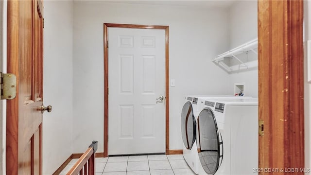 laundry room featuring laundry area, light tile patterned flooring, baseboards, and washing machine and clothes dryer