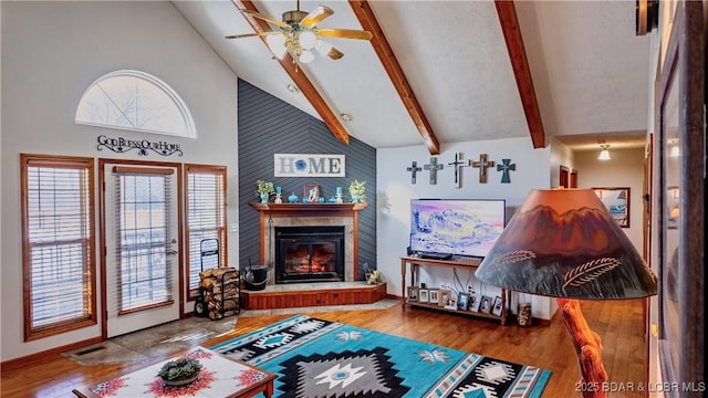 living room with beam ceiling, hardwood / wood-style flooring, high vaulted ceiling, and ceiling fan