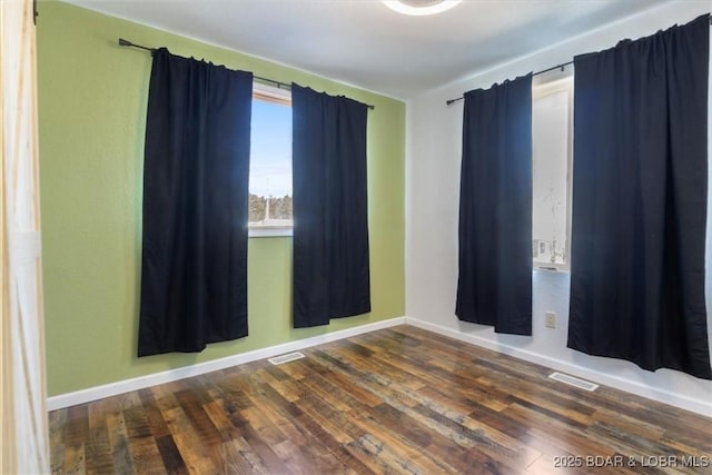 unfurnished room with dark wood-type flooring