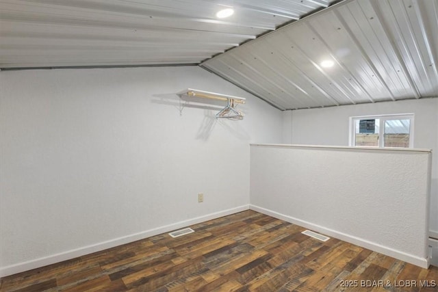 interior space featuring vaulted ceiling and dark hardwood / wood-style flooring