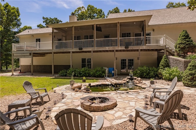 back of house featuring a lawn, a patio, and an outdoor fire pit