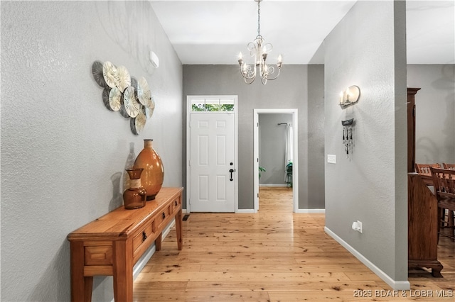 entryway with an inviting chandelier and light wood-type flooring